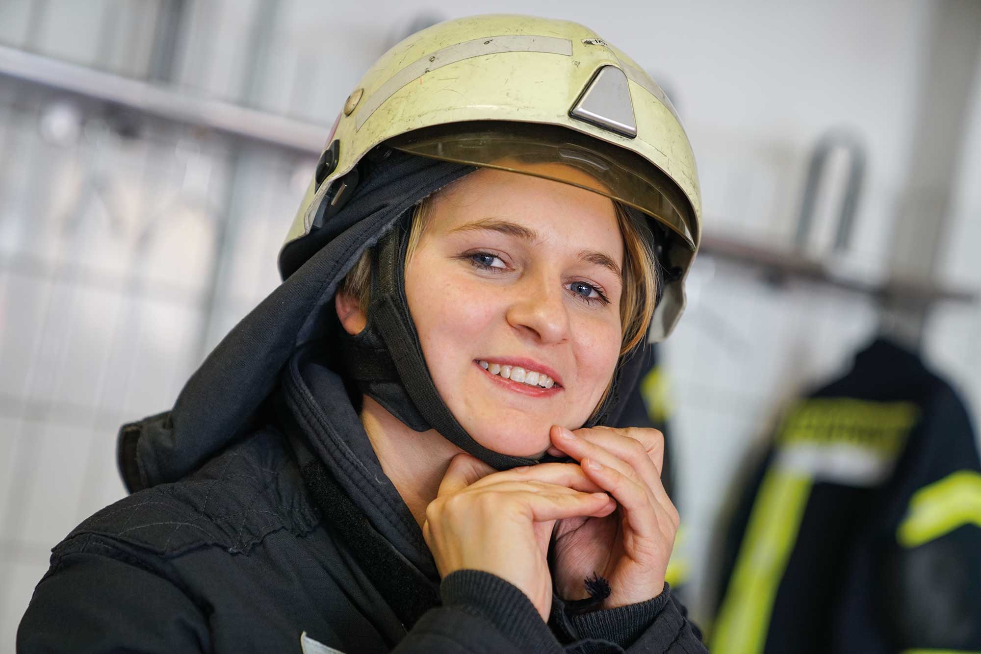 Die Zukunft der Feuerwehr: Eine junge, engagierte Feuerwehrfrau bereitet sich auf ihren Einsatz vor. Möchten Sie sich ebenfalls für unsere Gemeinschaft engagieren? Werden Sie Teil unseres Teams.